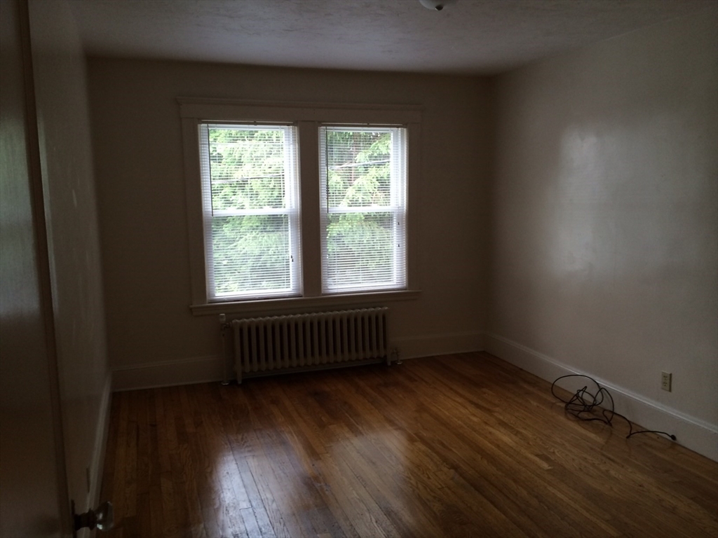 20 Prospect Avenue, Unit 8 Quincy, MA 02170 - Photo 10 of 13 an empty room with wooden floor and windows