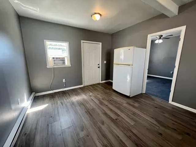 a view of a room with wooden floor and a window