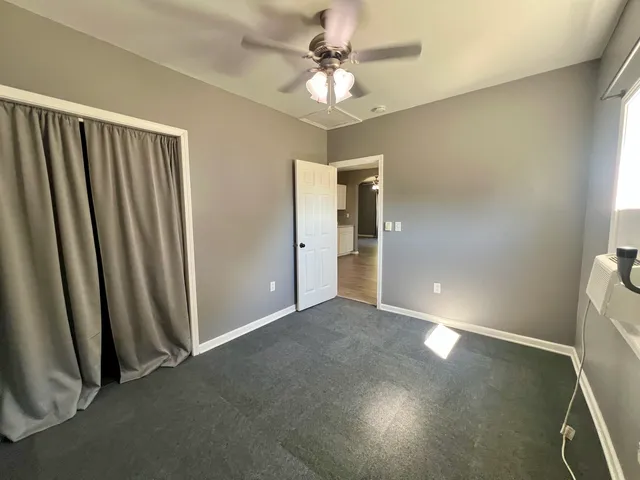 an empty room with fan and entrance