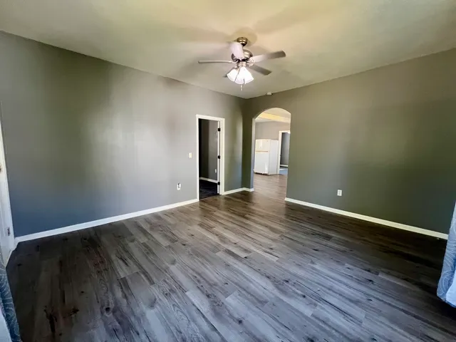 a view of an empty room with wooden floor