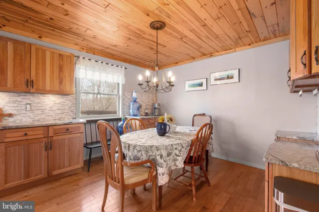 a dining room with furniture a chandelier and wooden floor