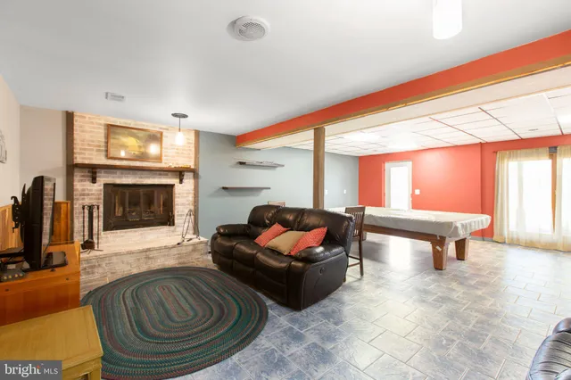 a living room with furniture a fireplace and a flat screen tv