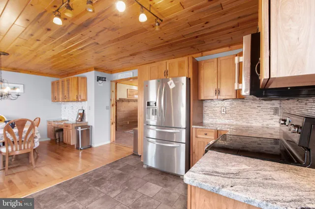 a kitchen with stainless steel appliances granite countertop a refrigerator and a stove top oven