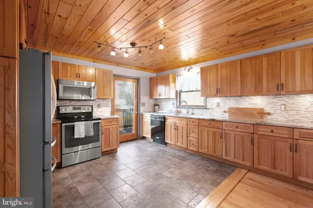 a kitchen with stainless steel appliances granite countertop a stove sink and cabinets