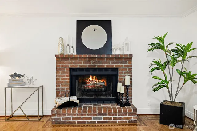 a living room with a fireplace a potted plant and a lamp