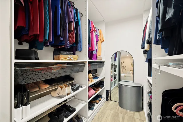 a view of walk in closet with clothes and shoes