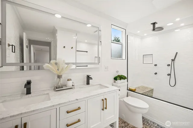 a bathroom with a granite countertop sink a toilet and mirror