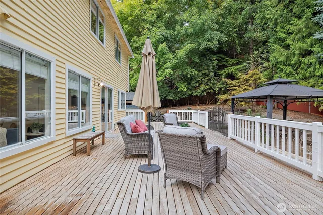 a view of a house with wooden deck and furniture