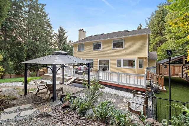 a view of a house with backyard and sitting area