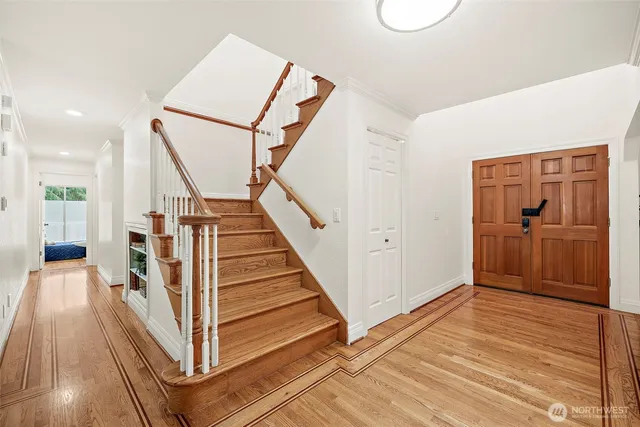 a view of a hallway with wooden floor and staircase