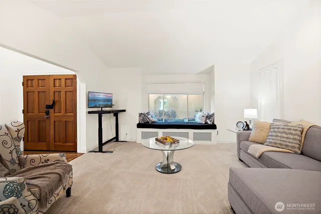 a living room with furniture a flat screen tv and a window