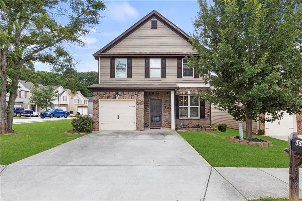 a front view of a house with a yard and garage