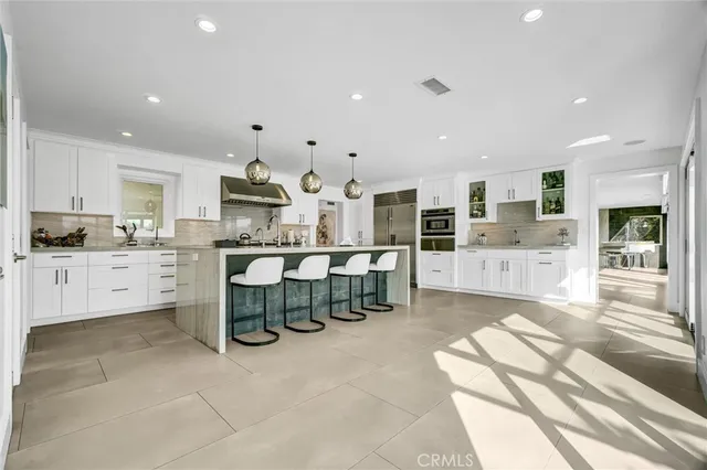 a kitchen with stainless steel appliances granite countertop a sink a stove and a refrigerator
