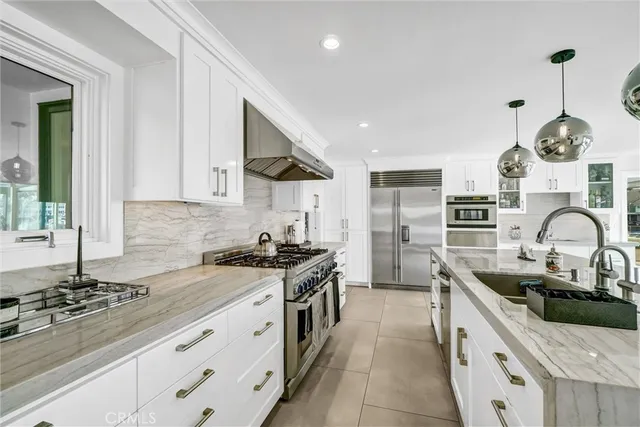 a kitchen with stainless steel appliances granite countertop a sink stove and cabinets