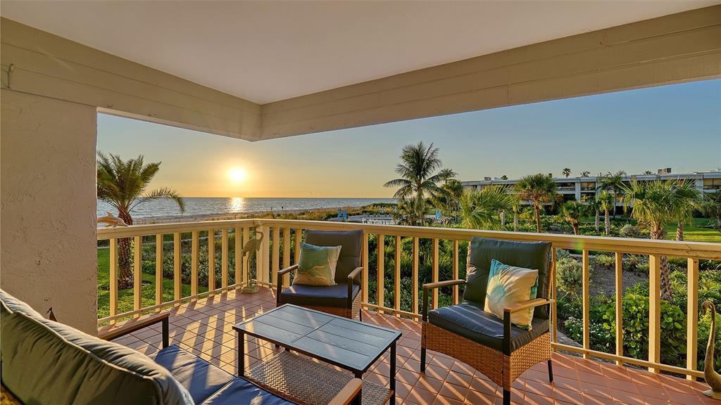 5757 Gulf Of Mexico Drive, Unit 204 Longboat Key, FL 34228 - Photo 15 of 71 a balcony with wooden floor and outdoor seating