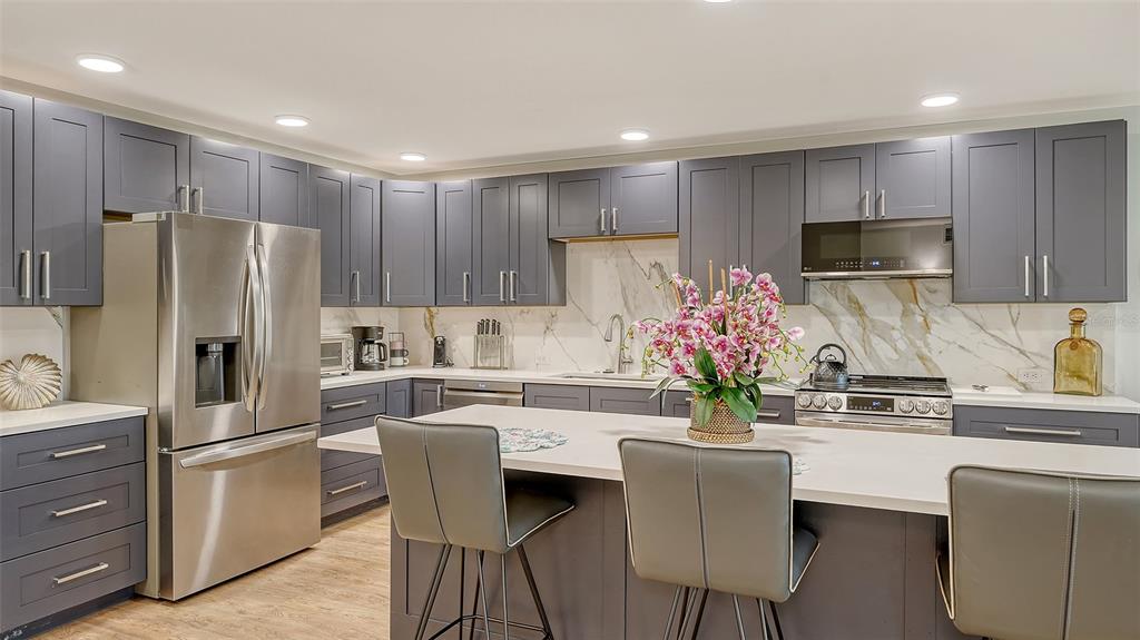 5757 Gulf Of Mexico Drive, Unit 204 Longboat Key, FL 34228 - Photo 29 of 71 a kitchen with kitchen island white cabinets and stainless steel appliances