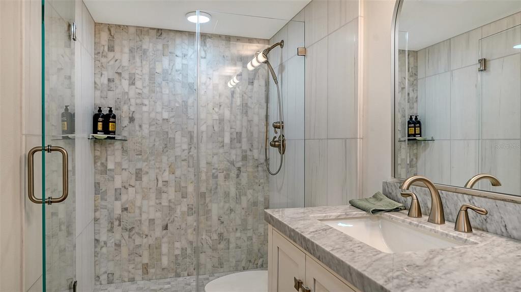 5757 Gulf Of Mexico Drive, Unit 204 Longboat Key, FL 34228 - Photo 42 of 71 a bathroom with a granite countertop sink a shower and a mirror