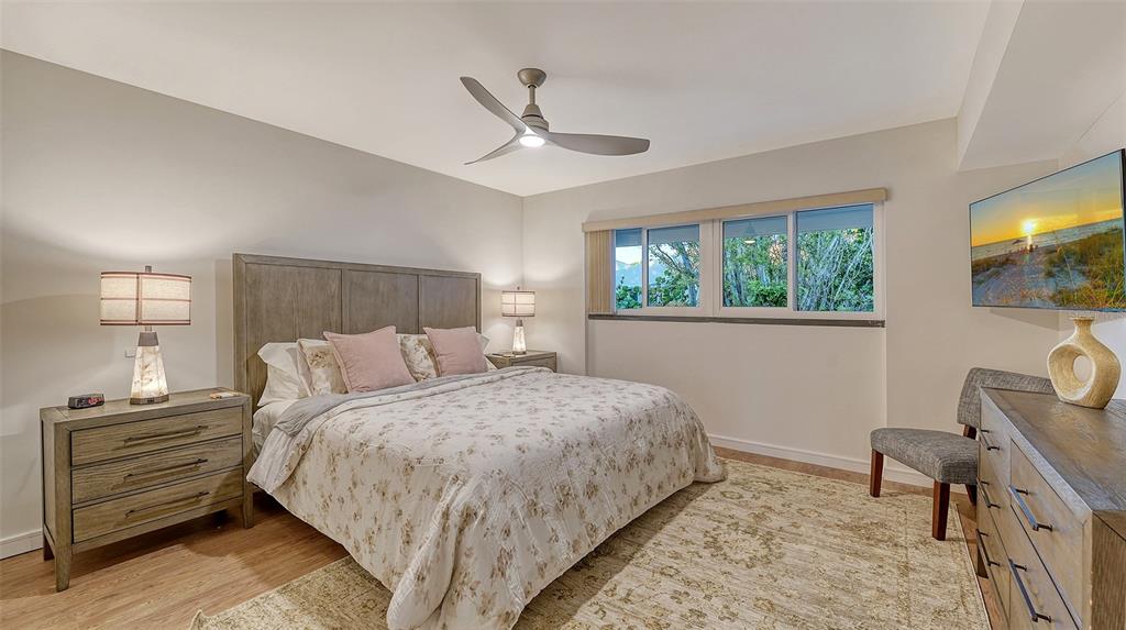 5757 Gulf Of Mexico Drive, Unit 204 Longboat Key, FL 34228 - Photo 44 of 71 a bedroom with a bed and a tv on table