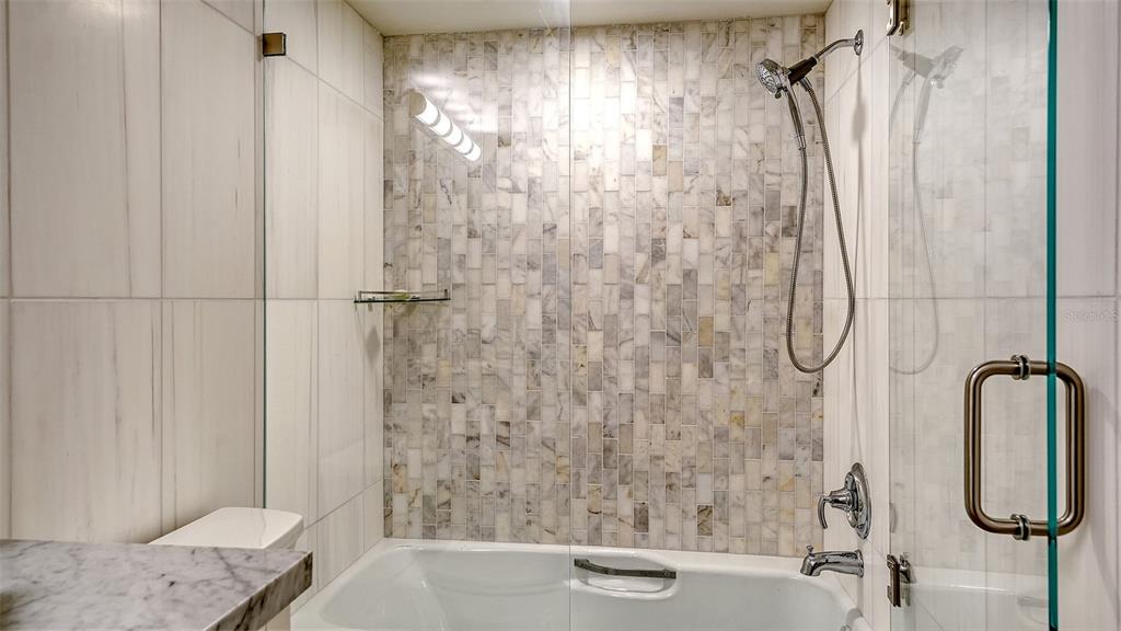 5757 Gulf Of Mexico Drive, Unit 204 Longboat Key, FL 34228 - Photo 48 of 71 a bathroom with a shower and a glass door shower