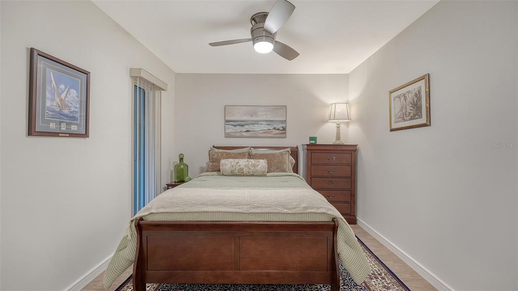 5757 Gulf Of Mexico Drive, Unit 204 Longboat Key, FL 34228 - Photo 50 of 71 a bedroom with a bed and a chandelier