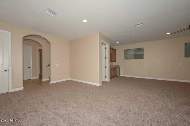 a large kitchen with stainless steel appliances a large counter top a sink and a refrigerator