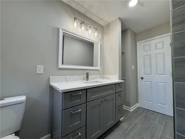 a bathroom with a toilet sink and mirror