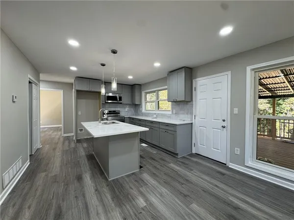 a view of a kitchen with a sink and wooden floor