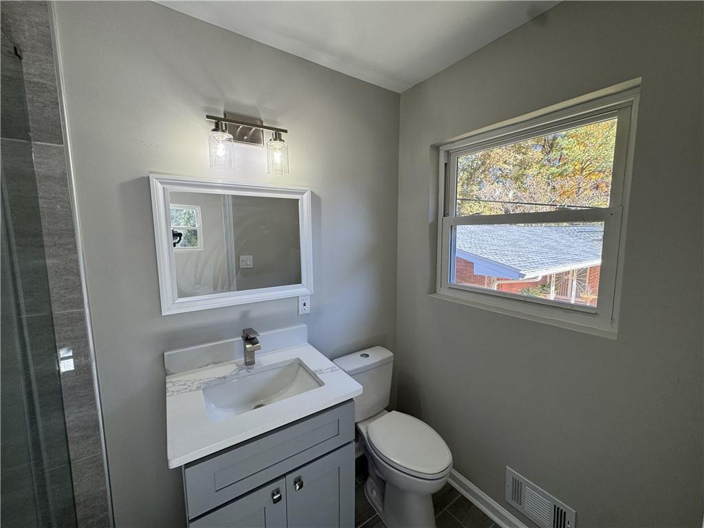 3489 Creighton Road Southwest Atlanta, GA 30331 - Photo 33 of 53 a bathroom with a toilet a sink a window and mirror