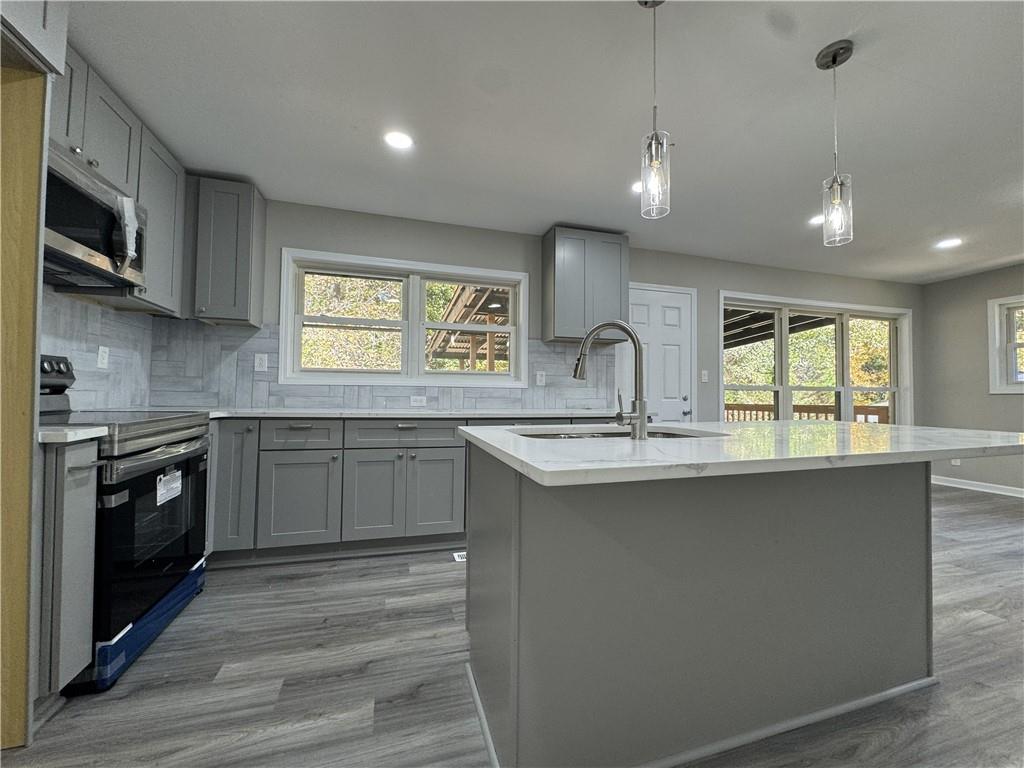 3489 Creighton Road Southwest Atlanta, GA 30331 - Photo 9 of 53 a kitchen with stainless steel appliances granite countertop a sink a stove a refrigerator cabinets and a wooden floor