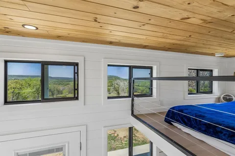 a view of a room with wooden floor and a window