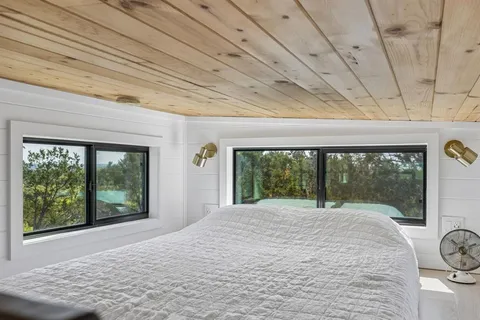 a bedroom with a bed and large window