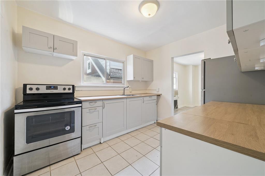 545 Sixth Street Trafford, PA 15085 - Photo 8 of 11 a kitchen with a stove top oven and cabinets