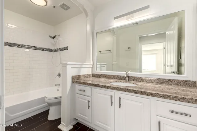 a bathroom with a granite countertop sink toilet and shower