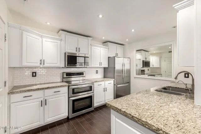 a kitchen with refrigerator cabinets and a sink
