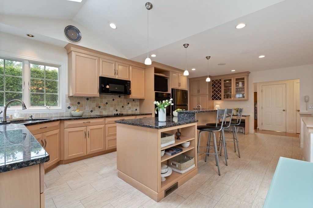 94 Cynthia Road Needham, MA 02494 - Photo 11 of 39 a kitchen with stainless steel appliances granite countertop a stove top oven a sink dishwasher a dining table and chairs with wooden floor