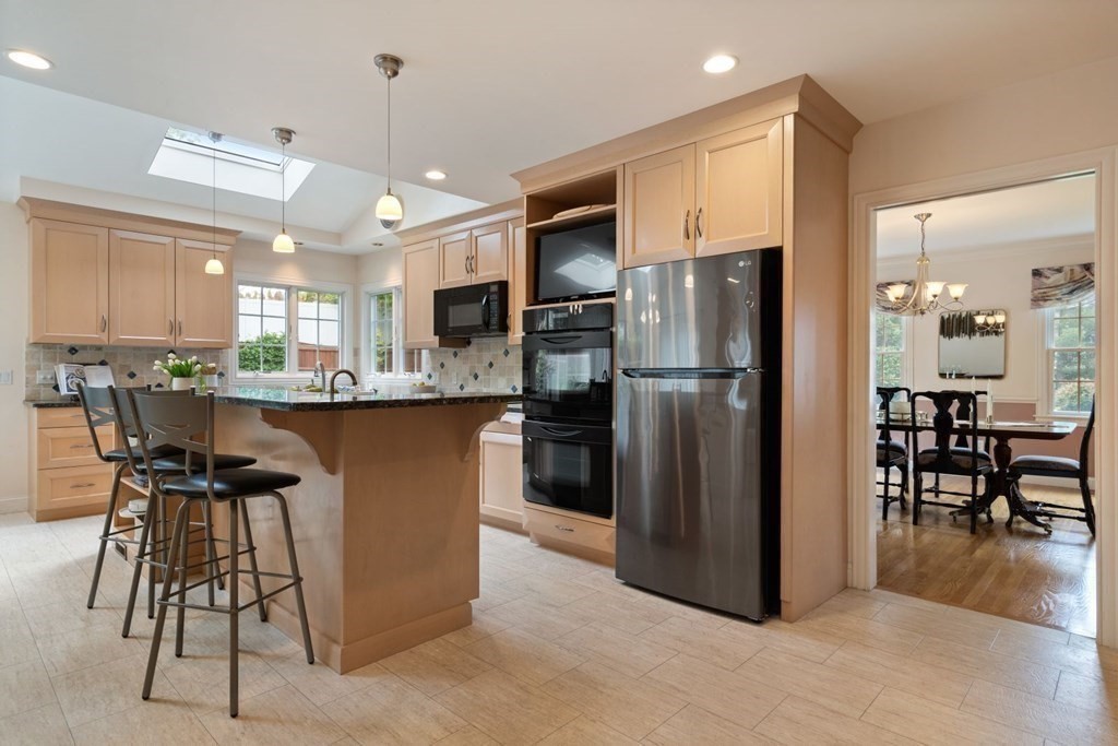 94 Cynthia Road Needham, MA 02494 - Photo 10 of 39 a kitchen with stainless steel appliances kitchen island granite countertop a refrigerator and a stove top oven