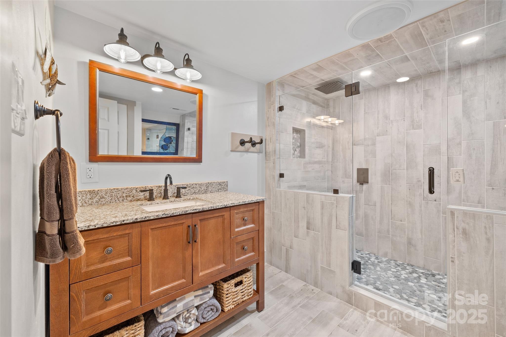 27056 Catamaran Drive Tega Cay, SC 29708 - Photo 25 of 48 a bathroom with a granite countertop sink a mirror a vanity and shower