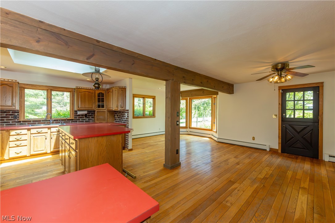 7969 Dines Road Novelty, OH 44072 - Photo 8 of 48 Open-concept kitchen featuring hardwood flooring, exposed wood beams, and a kitchen with wood cabinetry and a central island