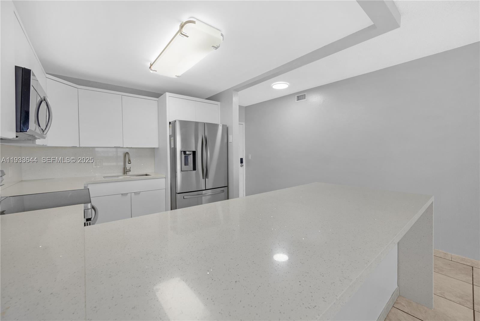 1750 West 46th Street, Unit 544 Hialeah, FL 33012 - Photo 3 of 44 a kitchen with stainless steel appliances a refrigerator and cabinets