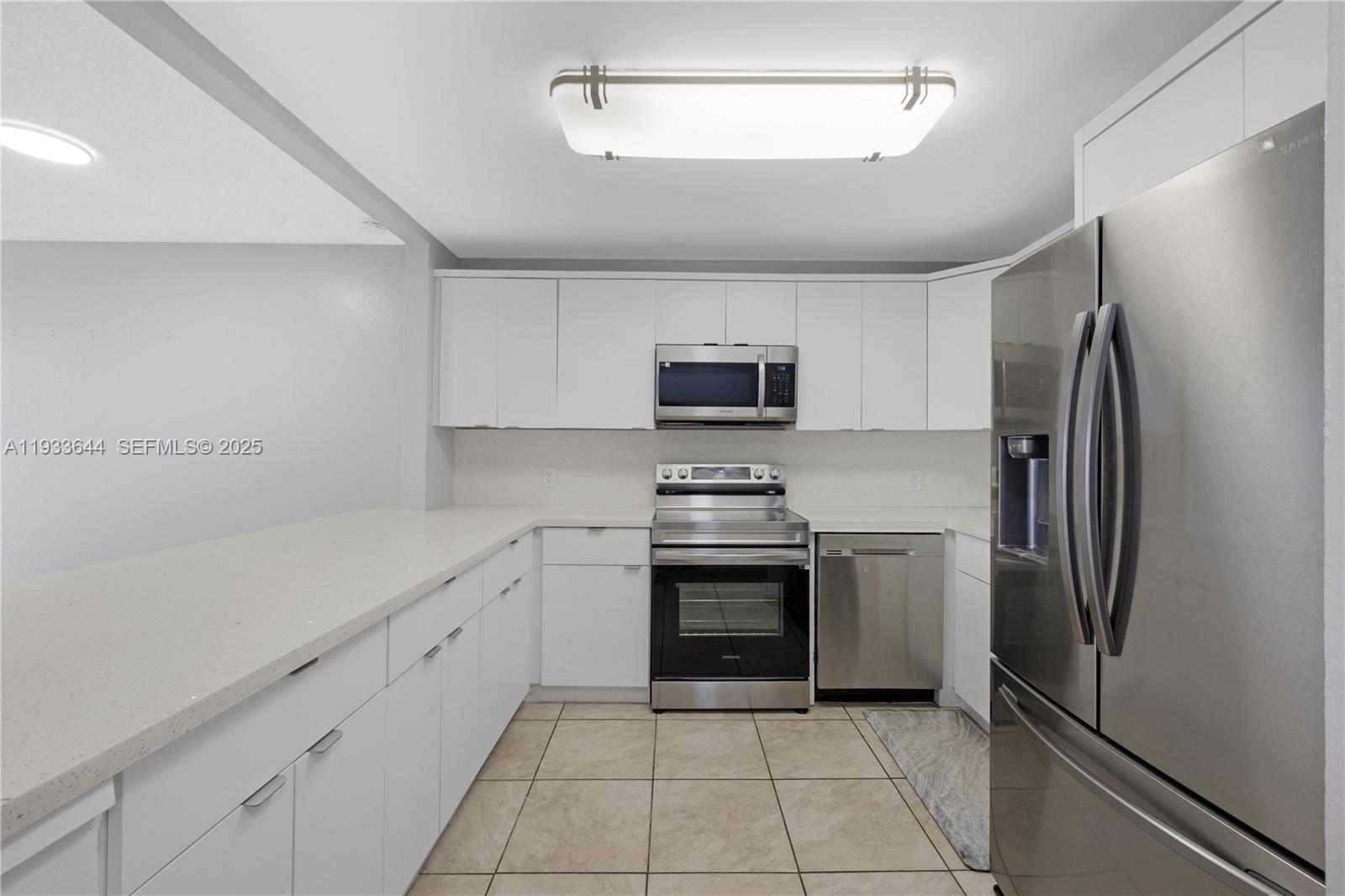 1750 West 46th Street, Unit 544 Hialeah, FL 33012 - Photo 5 of 44 a kitchen with stainless steel appliances a refrigerator sink and microwave