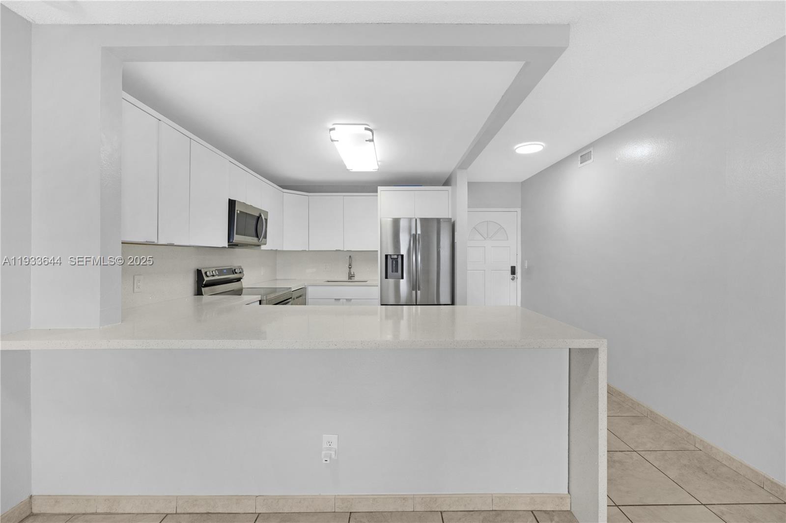1750 West 46th Street, Unit 544 Hialeah, FL 33012 - Photo 7 of 44 a large white kitchen with stainless steel appliances