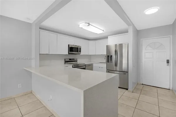 a view of a kitchen with a sink and a refrigerator