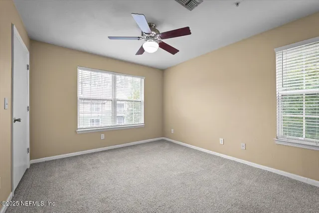 a view of an empty room with a ceiling fan