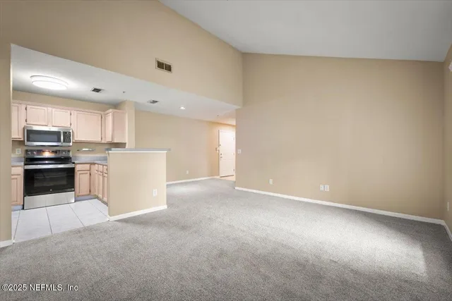 a kitchen with kitchen island a sink a refrigerator and white cabinets