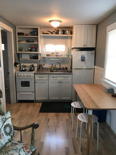 125 Shore Road, Unit 1 Truro, MA 02666 - Photo 3 of 8 a kitchen with kitchen island a stove a table and chairs in it