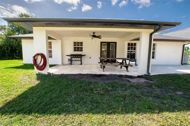 a view of a backyard with table and chairs and potted plants