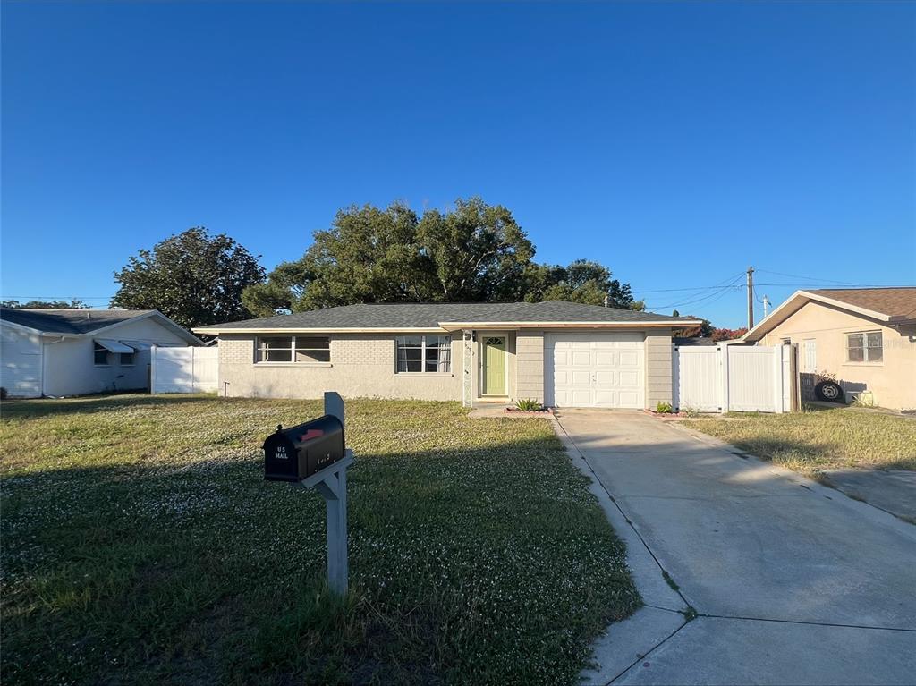 7539 Marechal Avenue Port Richey, FL 34668 - Photo 1 of 13 a front view of a house with a garden and yard