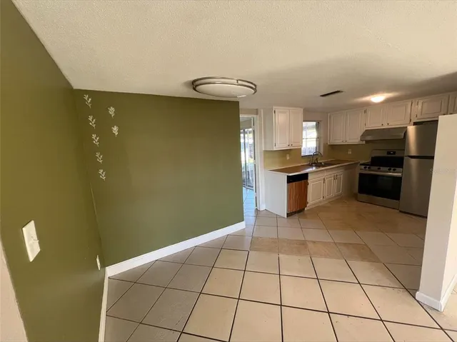 a kitchen with stainless steel appliances granite countertop a refrigerator a stove top oven and a sink