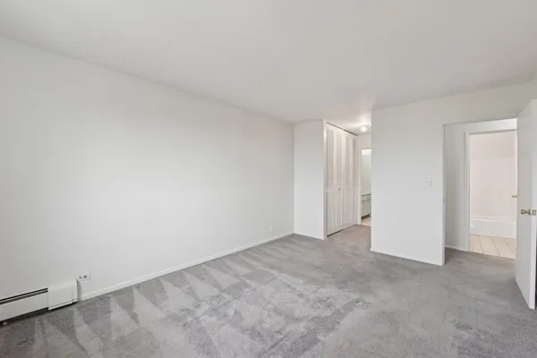 an empty room with windows and closet