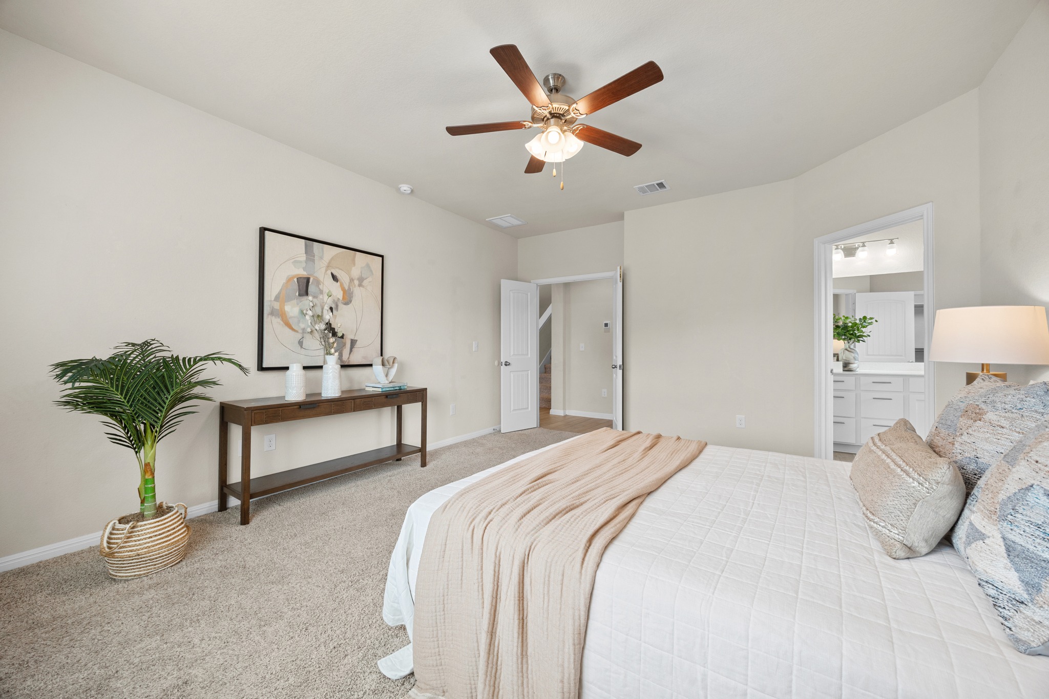 2413 Starhill Ranch Street Georgetown, TX 78628 - Photo 19 of 40 a bedroom with a large bed and a potted plant
